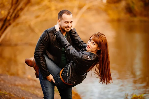 Άνδρας και γυναίκα φλερτάρουν στο πάρκο φθινόπωρο κοντά στο ποτάμι. — Φωτογραφία Αρχείου