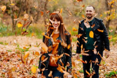 Erkekler sonbahar parkında kadınların üzerine kuru yapraklar yağdırır.. 