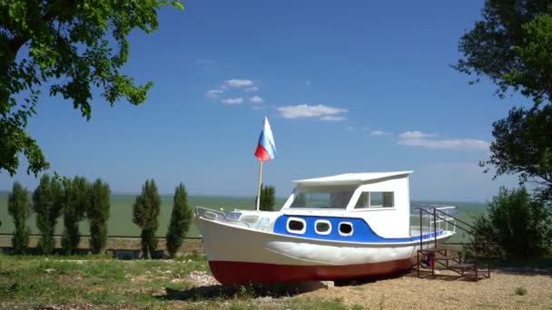 Παλιό σπασμένο σκάφος στην παραλία βαμμένο σε χρώματα της ρωσικής σημαίας με σημαία. — Αρχείο Βίντεο