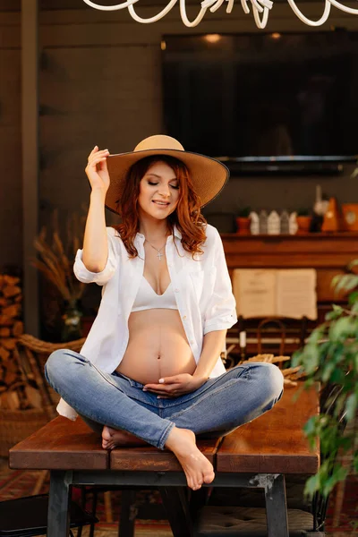 Gravid sitter på bordet på landet hus. — Stockfoto