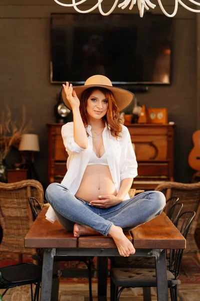 Gravid sitter på bordet på landet hus. — Stockfoto