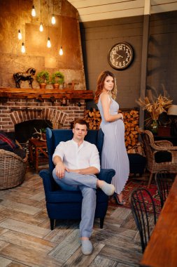 hamile ve şık giyimli bir adam kır evinde