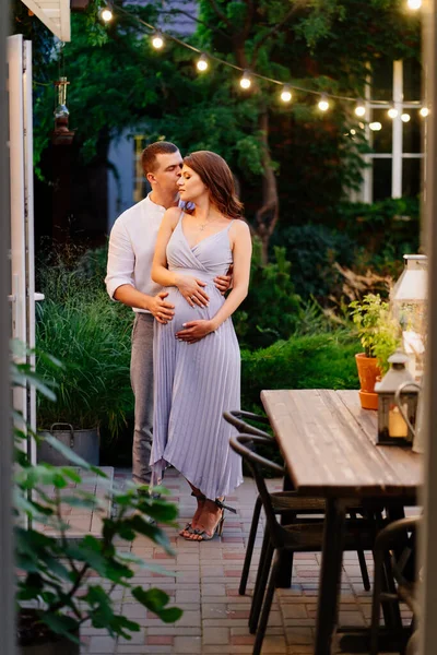 Terhes és férfi okos ruhák a kertben — Stock Fotó