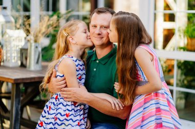 Babam evin bahçesinde iki tatlı kızı kucaklıyor..