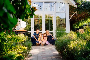 Hamile anne, baba ve iki kız kapı eşiğinde.