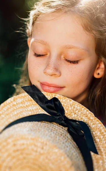 På nära håll. flicka med fräknar med halmhatt — Stockfoto