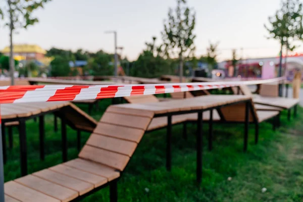 Absperrband. Geschlossener Sportplatz mit Holzbänken im Wohngebiet — Stockfoto