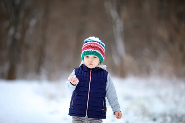 Meisje in kleurrijke hoed met sneeuwbal in haar hand. — Stockfoto
