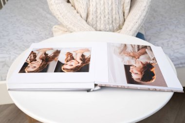 Beyaz masa üzerinde kalın sayfaları olan bir düğün fotoğrafı defteri..