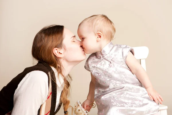 Mama küsst die kleine Tochter. Mütterliebe. — Stockfoto