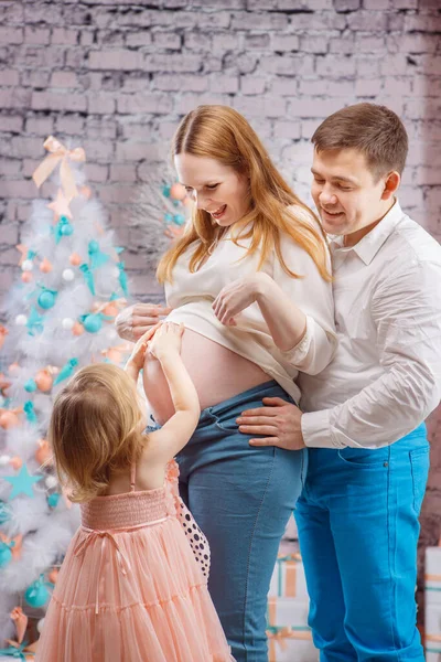 Figlia, papà e mamma incinta vicino all'albero di Natale — Foto Stock