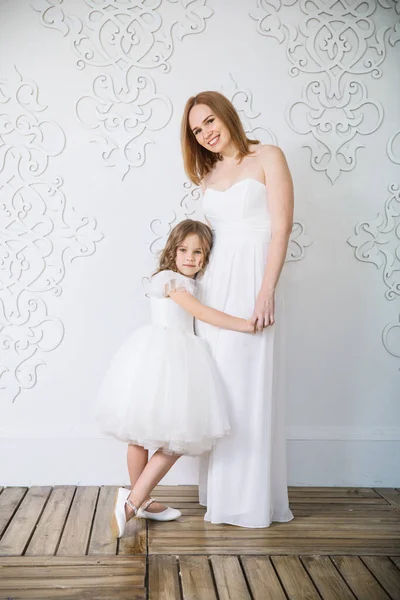 Matka a dcera v bílých večerních šatech. — Stock fotografie