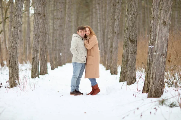 Un hombre y una mujer en un bosque de invierno cubierto de nieve. —  Fotos de Stock
