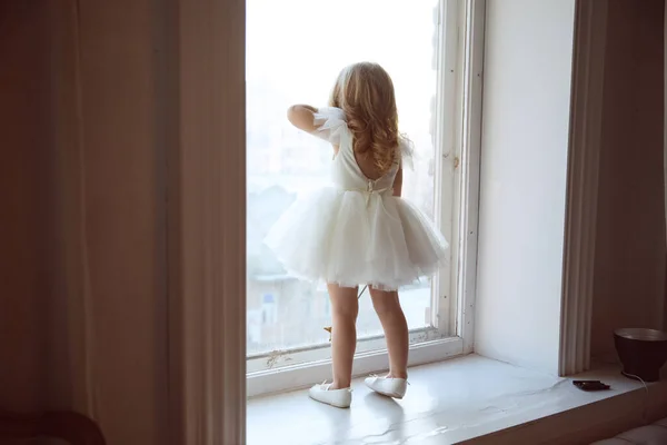 Маленька дівчинка біля вікна чекає на Санта Клауса. — стокове фото
