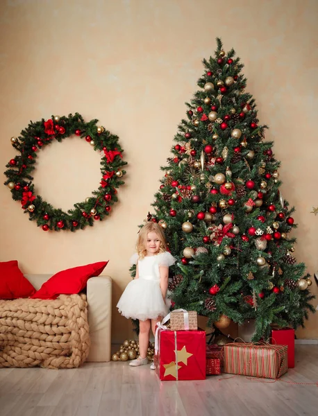 Menina no fundo de árvores de Natal no sótão. — Fotografia de Stock