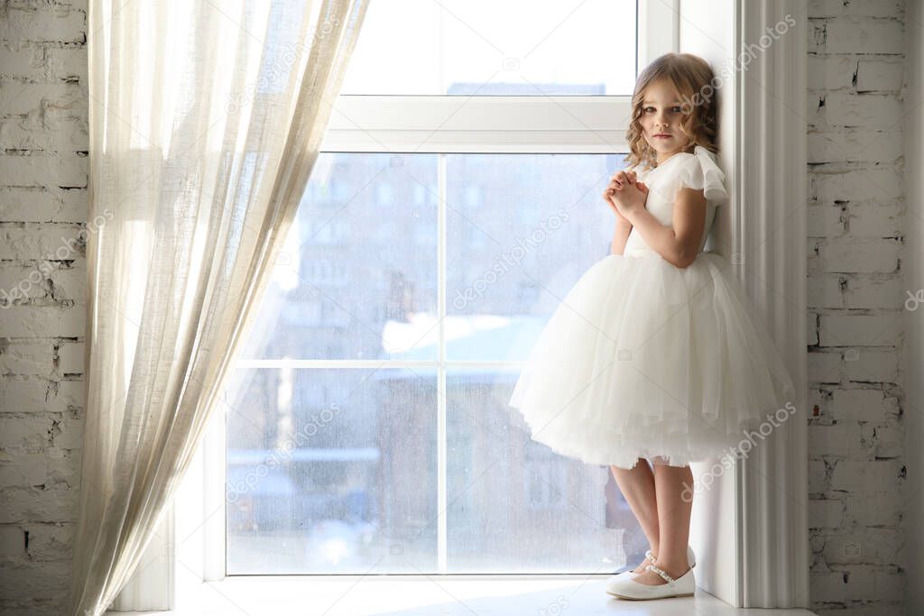 kid girl is waiting for Santa Claus at window.