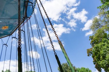 Zincirler ve gökyüzü üzerindeki atlıkarıncanın alt görüntüsü