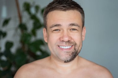 Bir tarafı sakallı, diğer tarafı tıraşlı mutlu bir adam.