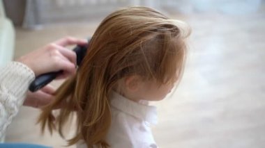 Anne saçlarını tararken tatlı bir okul kızı oturuyor. Erken kalkar okula.