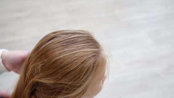 Samping tampilan. Gadis sekolah yang manis menguap sementara ibu menyisir rambut. — Stok Video