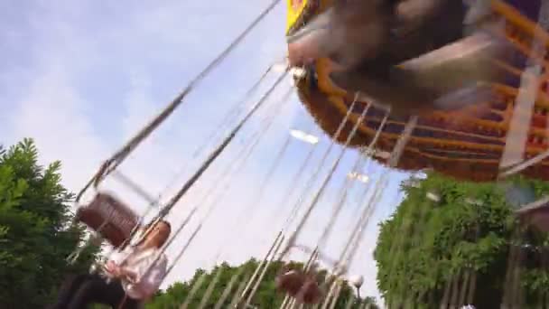 Карусель цепи вращается в парке аттракционов. семейная поездка качели в выходные — стоковое видео