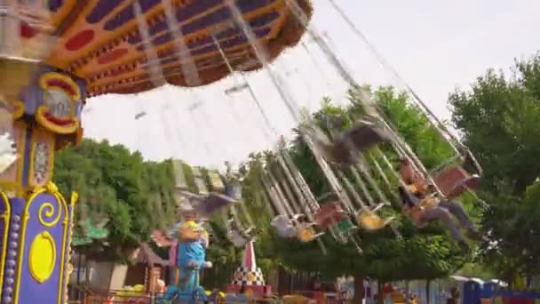 Körhinta forog a vidámparkban. lányok lovagolni swing hétvégén. — Stock videók