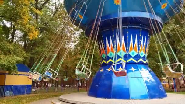 Карусель ланцюга обертається в парку розваг. дівчата катаються на гойдалках у вихідні — стокове відео