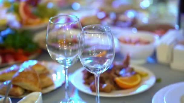 Dos copas de vino vacías en la mesa de comedor festiva. música de color. — Vídeo de stock