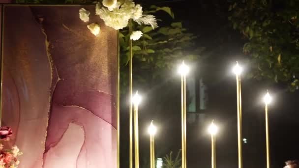 Esküvői dekoráció éjjel a kertben. a kilépési ceremónia helyszíne este. — Stock videók