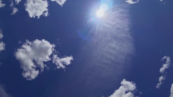 Le mouvement des nuages sur le fond du ciel bleu, la direction de prise de vue vidéo verticalement vers le haut. Flux d'air accéléré avec cumulus et cirrus et soleil d'été éclatant .