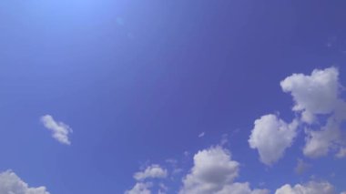Parlak güneşli bir günde mavi gökyüzünde bulutlar. Atmosferik olayların dikey hızlandırılmış çekimi.