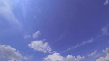 Parlak güneşli bir günde mavi gökyüzünde bulutlar. Atmosferik olayların dikey hızlandırılmış çekimi.