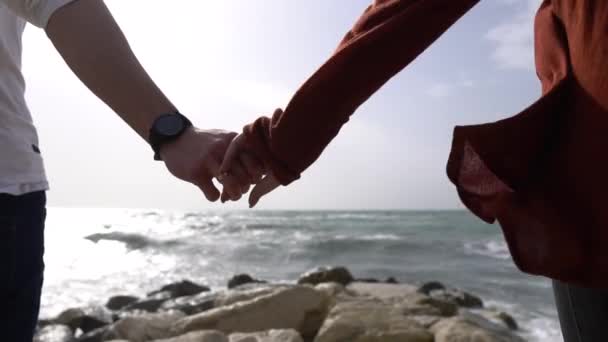 คู่รักจับมือกันบนพื้นหลังของทะเล — วีดีโอสต็อก