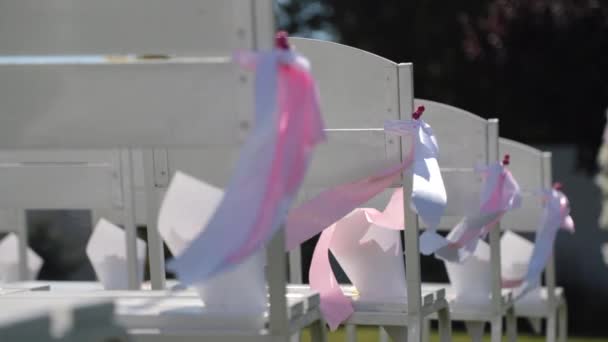 Cintas se balancean en el viento en sillas de boda — Vídeo de stock