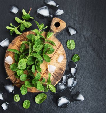 Yeşil nane ve buz siyah bir taş zemin üzerine