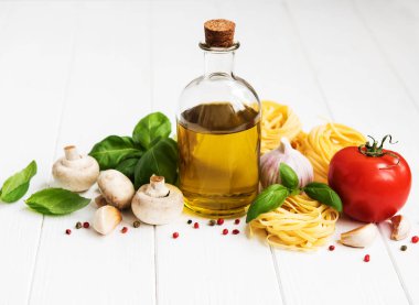 İtalyan gıda katkı maddeleri, zeytinyağı, baharat, makarna ve domates Beyaz ahşap bir masa üzerinde