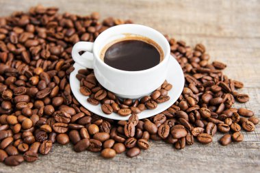 Bir fincan kahve ve kızarmış kahve çekirdeği.