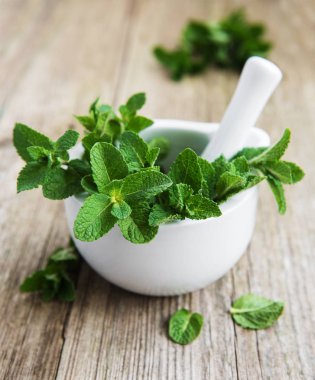 Eski ahşap bir masa üzerinde taze nane ile harç