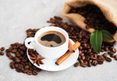 Bir fincan kahve ve kızarmış kahve çekirdeği.