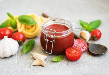 Domates sosu ve malzemeler taş zemin üzerine kavanoz