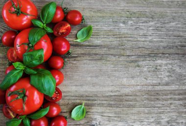 Eski bir ahşap zemin üzerine Yeşil fesleğen ile taze domates