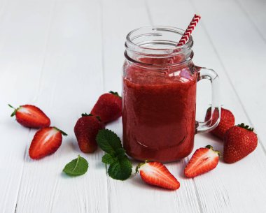 Ahşap bir masa üzerinde çilek güler yüzlü ile jar