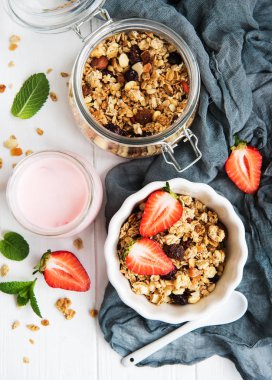 Beyaz ahşap bir masa üzerinde çilek ile ev yapımı granola