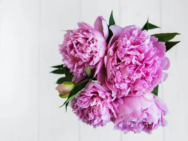 Beyaz ahşap bir masa pembe şakayık çiçekleri