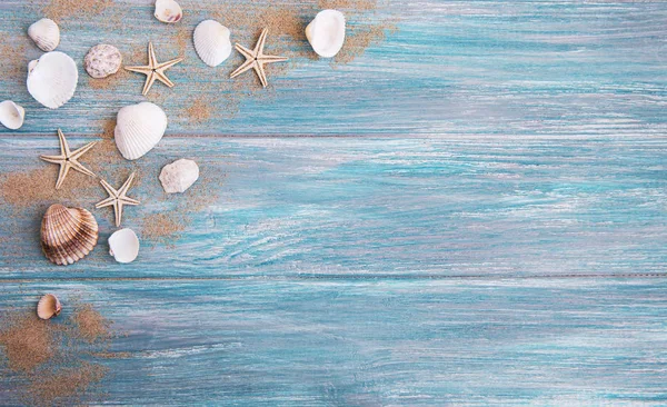 deniz kabukları ahşap arka plan üzerinde kum ile