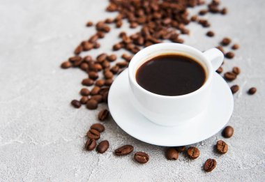 Bir fincan kahve ve kızarmış kahve çekirdeği.