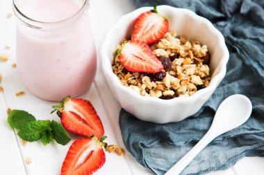 Beyaz ahşap bir masa üzerinde çilek ile ev yapımı granola