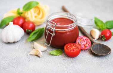 Domates sosu ve malzemeler taş zemin üzerine kavanoz