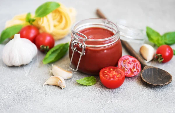 Domates sosu ve malzemeler taş zemin üzerine kavanoz