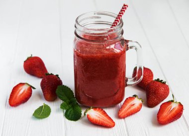 Ahşap bir masa üzerinde çilek güler yüzlü ile jar